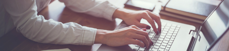 Hands typing on a keyboard. 